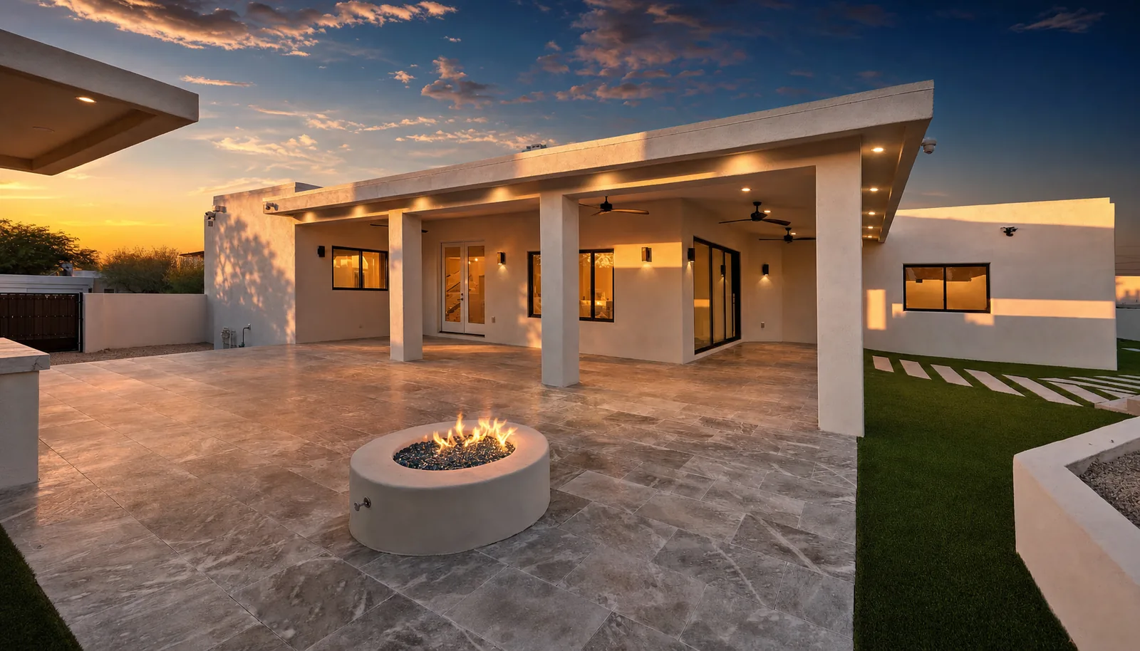 Covered patio with a gas fire feature and travertine paving on a completed new construction home in the Phoenix Valley